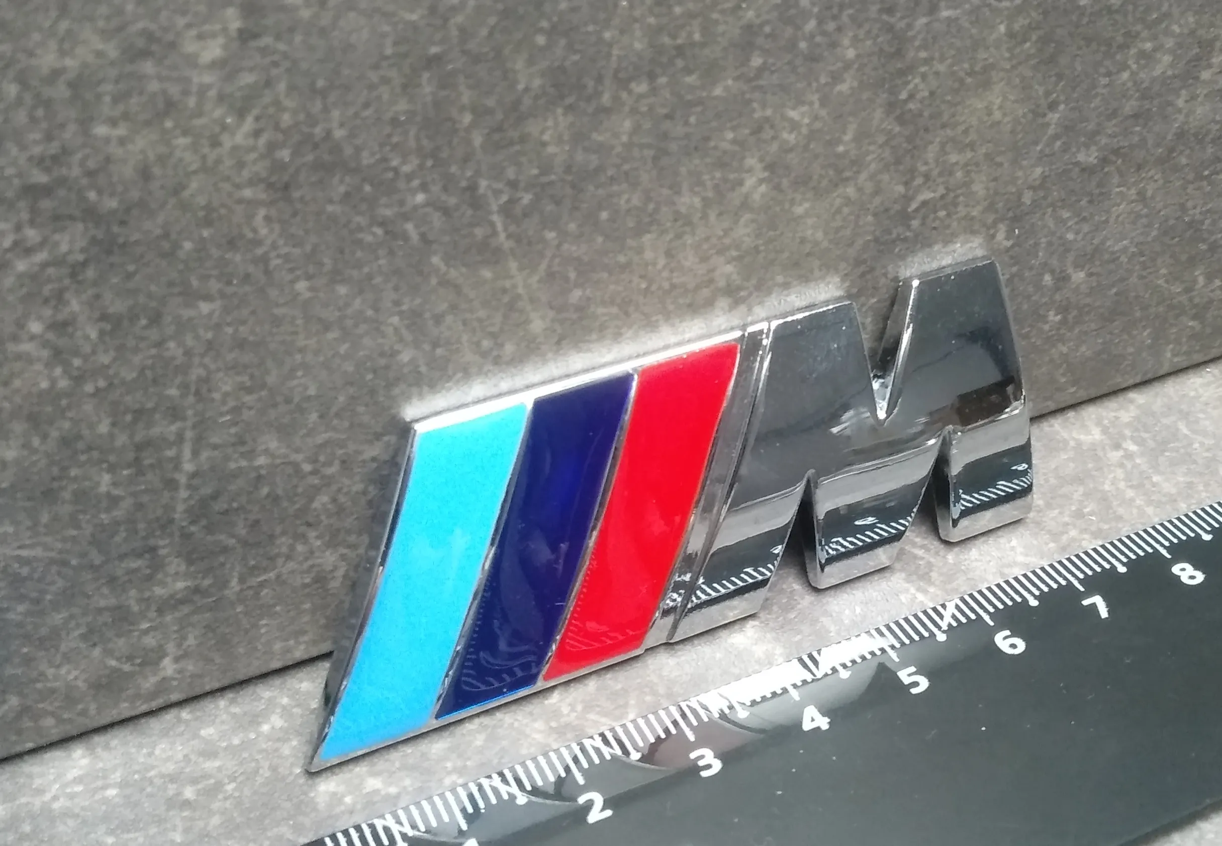 Наклейка на крышку багажника "M", серебр., металл + скотч (72mm*27mm)
