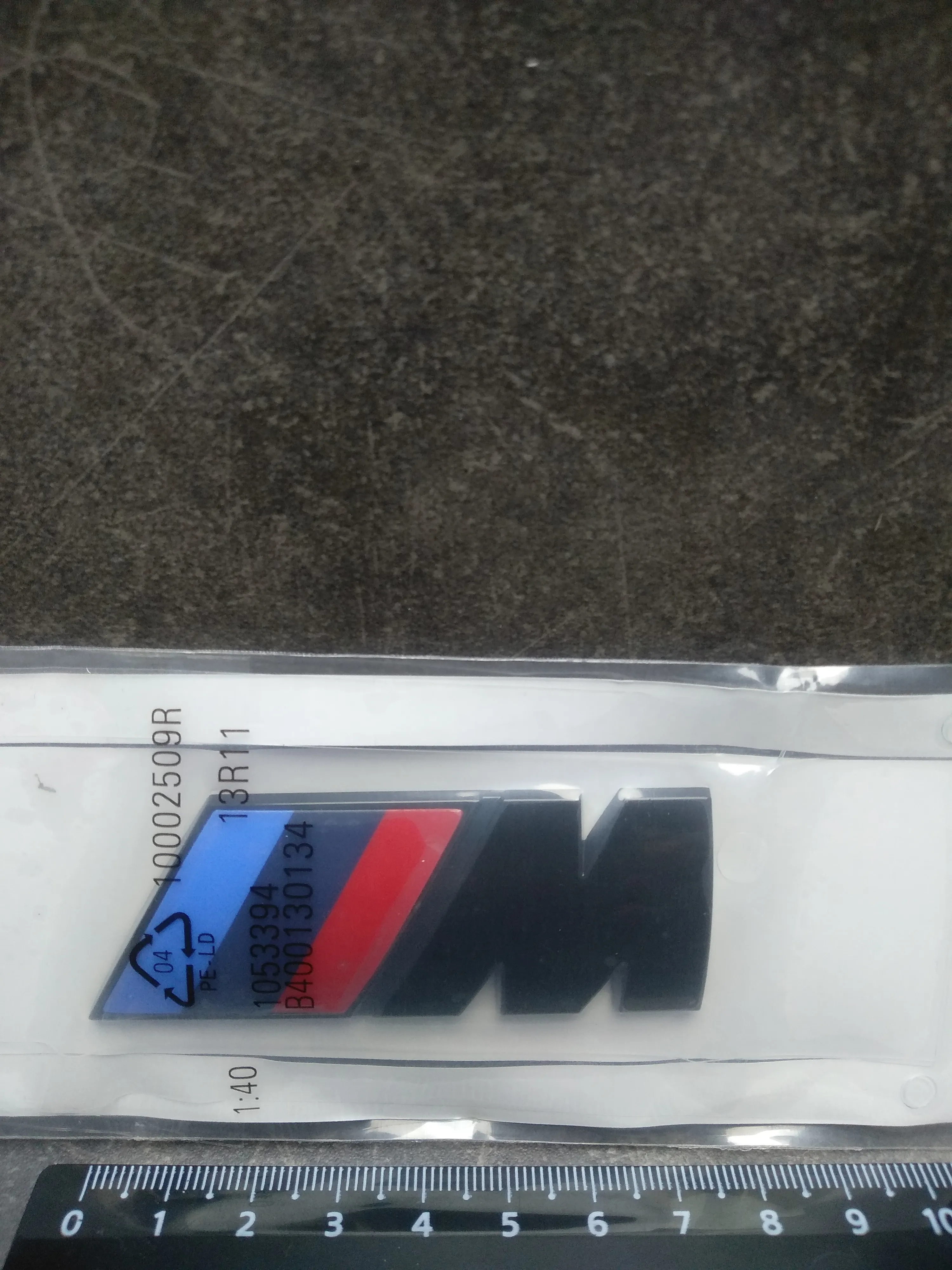 Наклейка на крышку багажника "M", чёрная, металл + скотч (72mm*27mm)